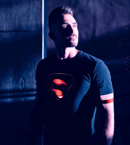 Фото мужчины атлета в черной футболке с логотипом Супермена.